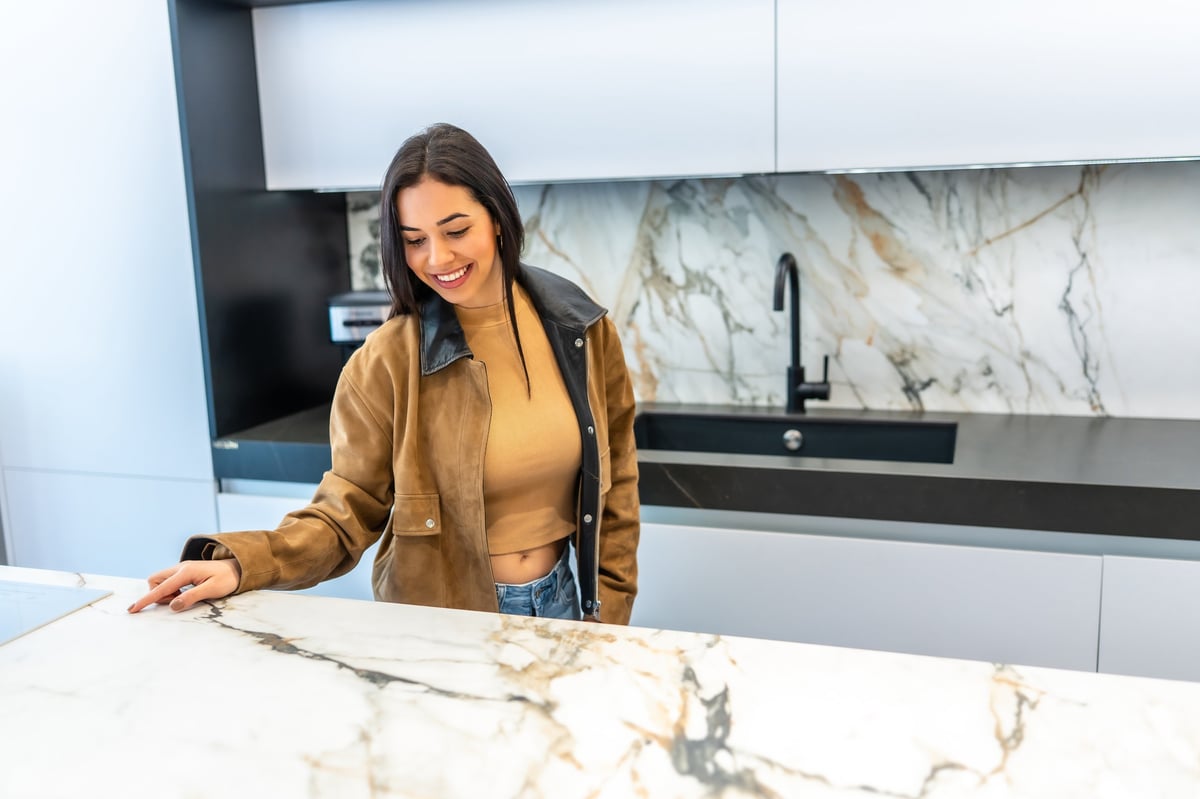 Homeowner inspecting a marble countertop in a modern kitchen