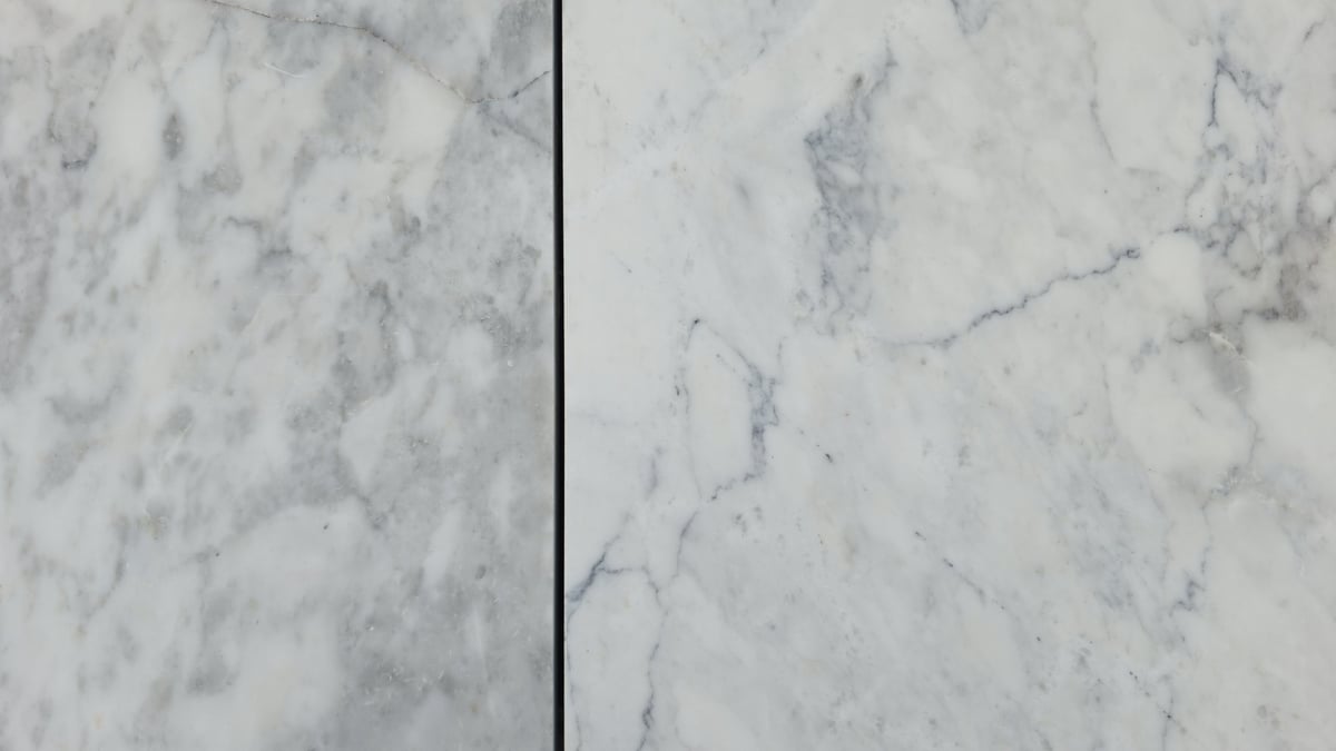 Luxury white marble wall tiles with visible seams and grey veins — seam separation and lippage repair