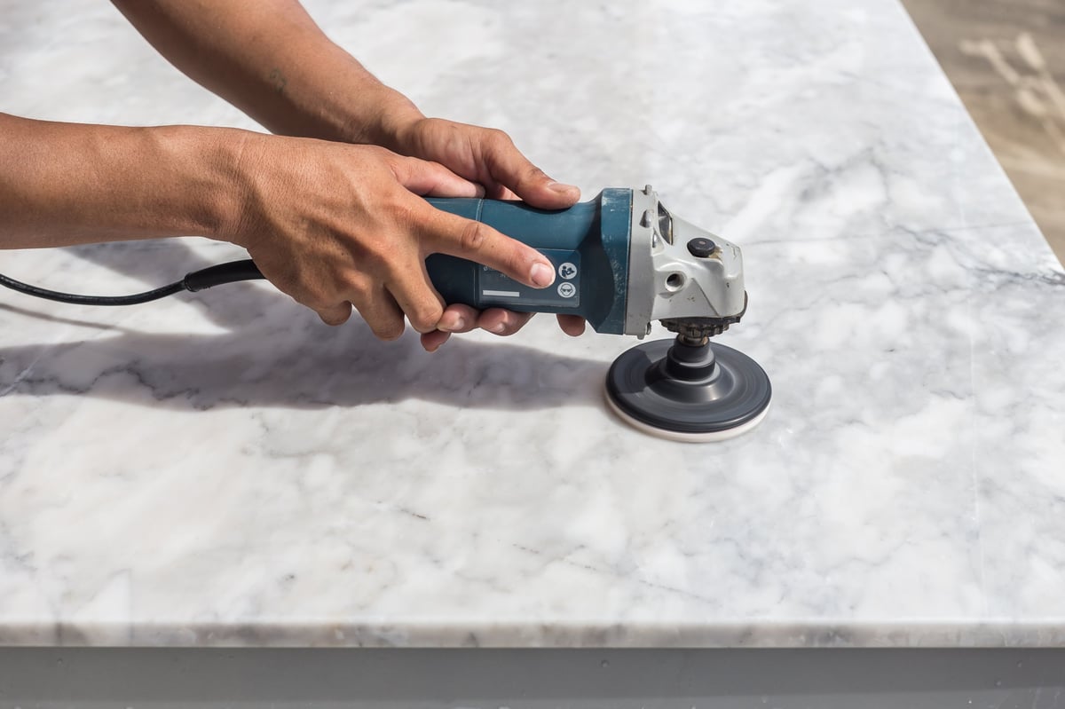 Professional technician polishing marble stone countertop with angle grinder — Refresh Countertops Westchester