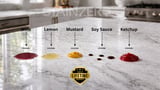 Stain samples on marble counter showing wine, lemon, mustard, soy sauce, and ketchup